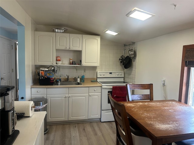 356 Montgomery Ave, West Babylon, NY 11704 - kitchen featuring white electric range oven, lofted ceiling, tasteful backsplash, light wood-style floors, and light countertops