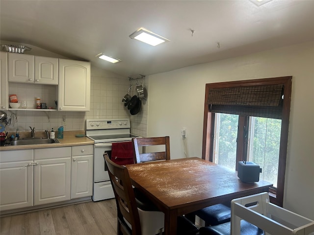 356 Montgomery Ave, West Babylon, NY 11704 - kitchen with electric range, vaulted ceiling, light wood-type flooring, decorative backsplash, and white cabinets
