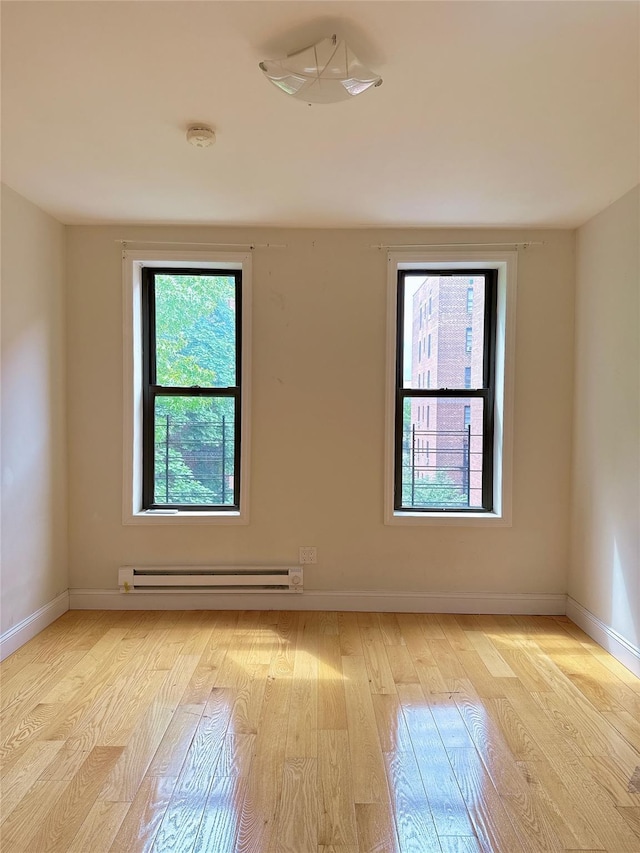 132-30 Sanford Ave Unit 4F, Flushing, NY 11355 - empty room with a baseboard heating unit and light wood-style floors
