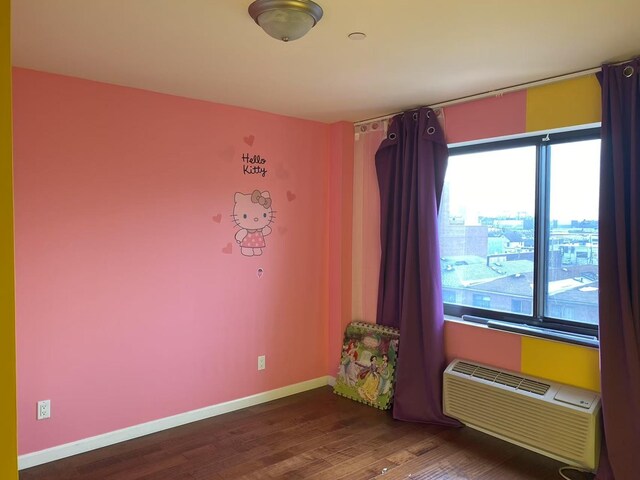 3138 137th St Unit 5A, Flushing, NY 11354 - empty room with wood finished floors and a wall mounted AC