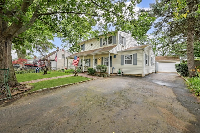 129 Spring Ln, Levittown, NY 11756 - view of front of house with driveway, an outbuilding, a front lawn, covered porch, and a detached garage