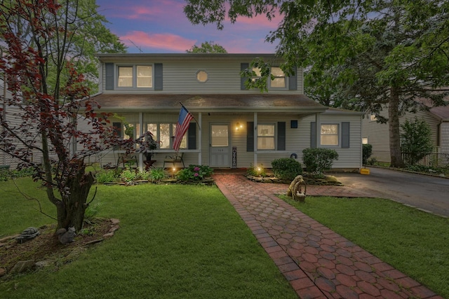 129 Spring Ln, Levittown, NY 11756 - traditional-style house featuring covered porch and a front yard