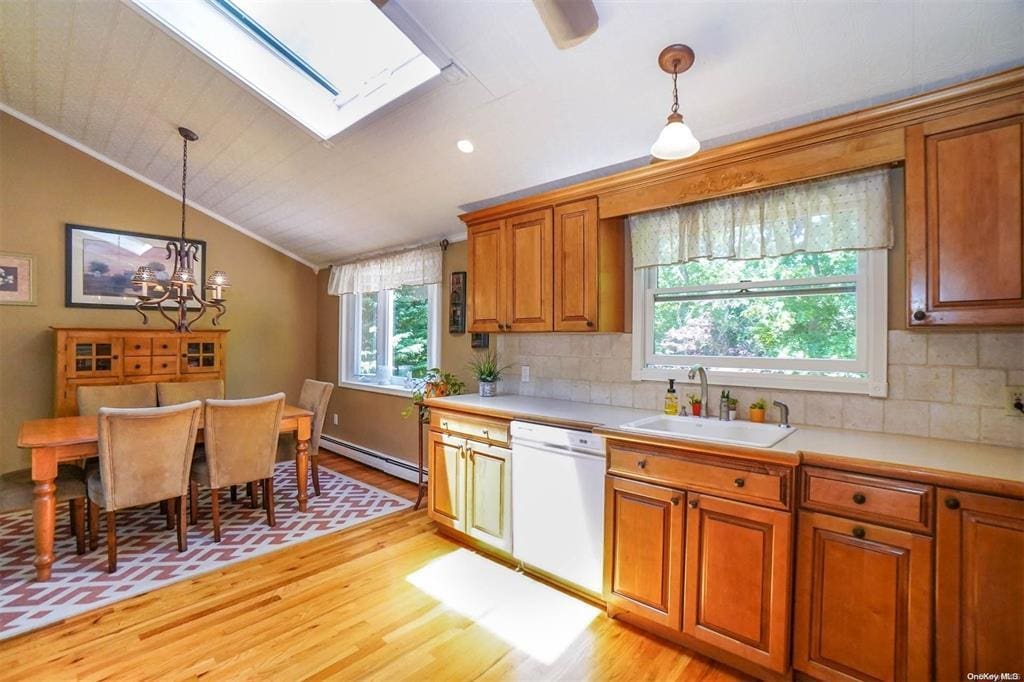 35 40th St, Islip, NY 11751 - kitchen with dishwasher, baseboard heating, vaulted ceiling, light wood-style flooring, and brown cabinets