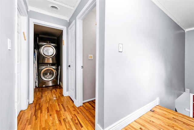 22 Sharon Dr, Spring Valley, NY 10977 - laundry room featuring stacked washer / dryer, ornamental molding, and light wood-type flooring