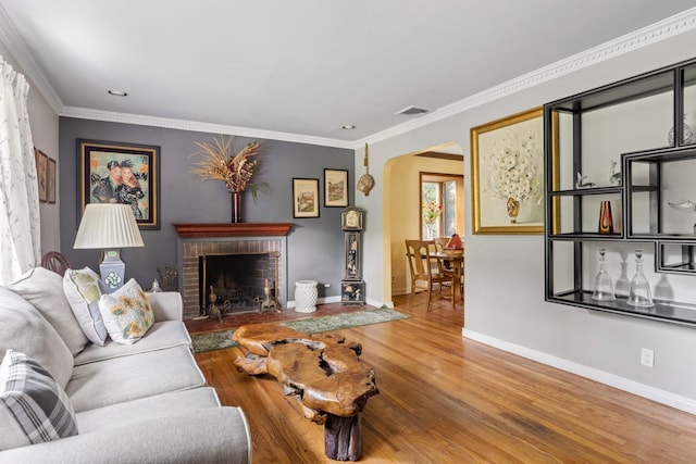 77 Nancy Blvd, Merrick, NY 11566 - living area featuring arched walkways, wood finished floors, a brick fireplace, and ornamental molding