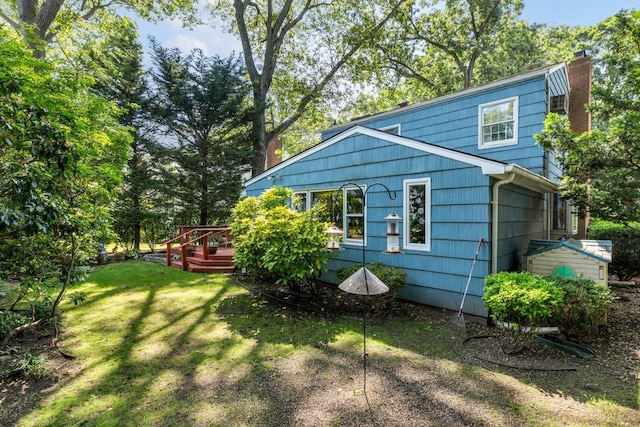 77 Nancy Blvd, Merrick, NY 11566 - view of side of property featuring a lawn, a wooden deck, and a chimney