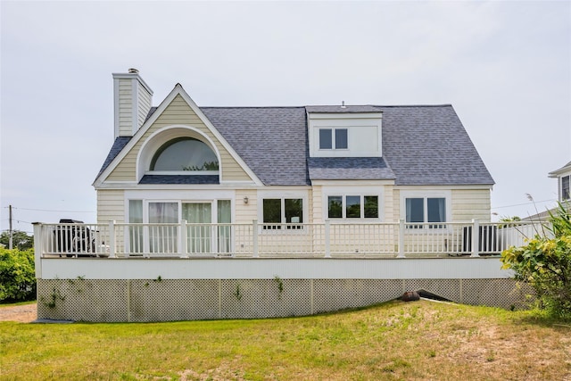 10 Bayview Rd, Remsenburg, NY 11960 - rear view of property featuring roof with shingles, a deck, a chimney, and a lawn