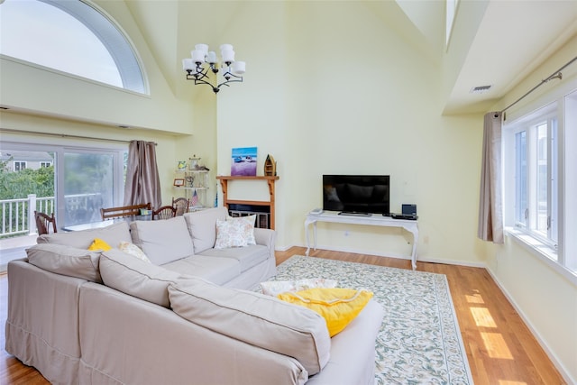 10 Bayview Rd, Remsenburg, NY 11960 - living room with high vaulted ceiling, a chandelier, light wood-style floors, and plenty of natural light