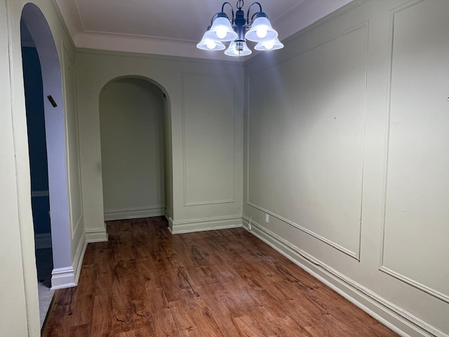 1 Meadow Dr Unit 3D, Woodmere, NY 11598 - empty room featuring arched walkways, wood finished floors, a chandelier, and a decorative wall
