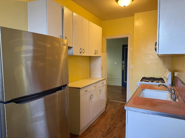 1 Meadow Dr Unit 3D, Woodmere, NY 11598 - kitchen featuring freestanding refrigerator, gas range gas stove, dark wood-type flooring, light countertops, and white cabinets