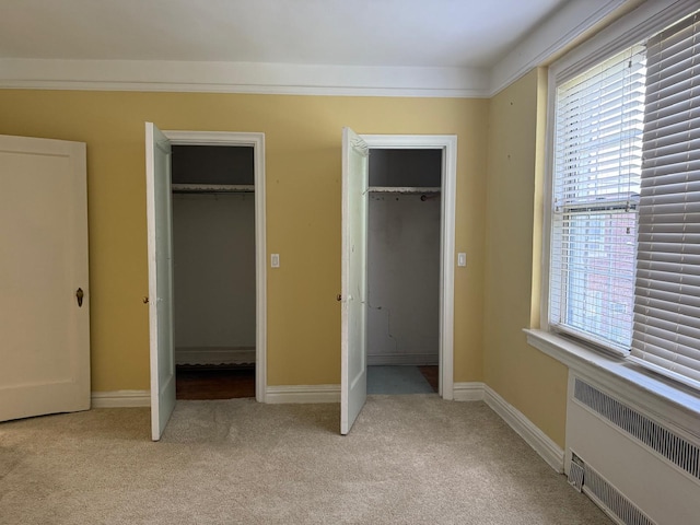 1 Meadow Dr Unit 3D, Woodmere, NY 11598 - unfurnished bedroom with radiator heating unit, multiple windows, and light colored carpet