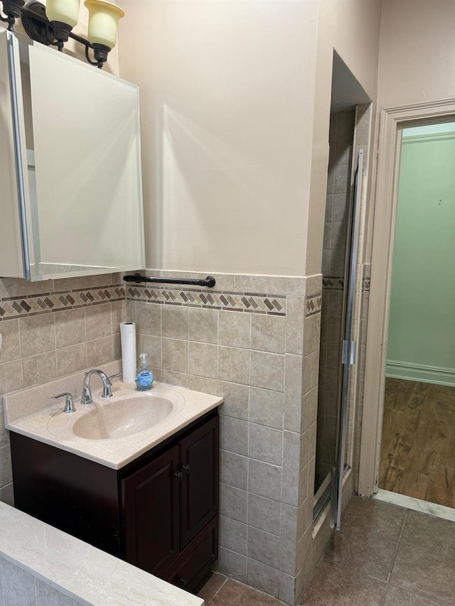 1 Meadow Dr Unit 3D, Woodmere, NY 11598 - full bathroom featuring vanity, tile walls, a shower stall, wainscoting, and tile patterned flooring
