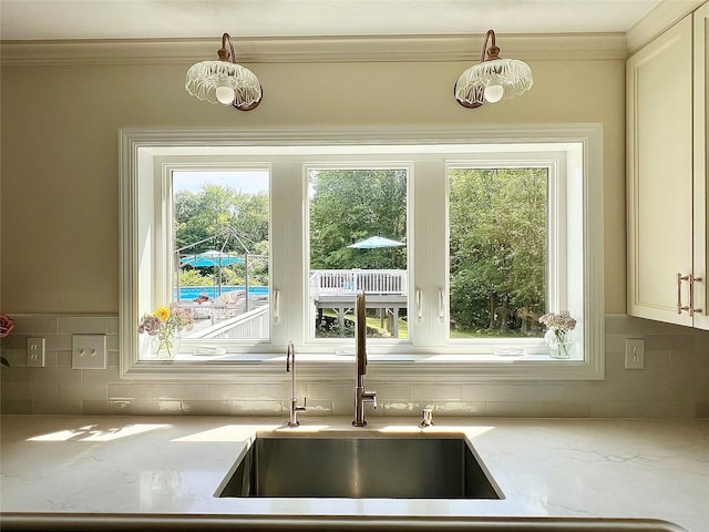 306 S Centerville Rd, Middletown, NY 10940 - kitchen featuring tasteful backsplash, light stone counters, plenty of natural light, ornamental molding, and pendant lighting