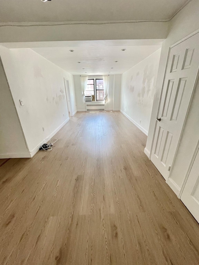 8385 116th St Unit 4B, Kew Gardens, NY 11418 - empty room with light wood-style flooring and radiator heating unit