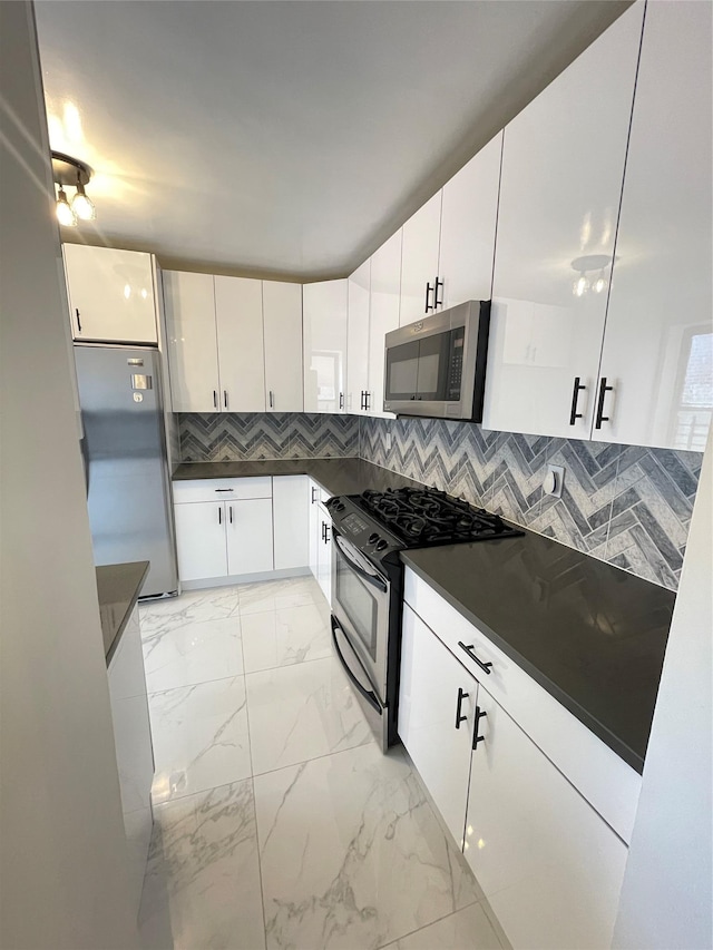 8385 116th St Unit 4B, Kew Gardens, NY 11418 - kitchen featuring appliances with stainless steel finishes, dark countertops, light marble finish flooring, white cabinets, and decorative backsplash