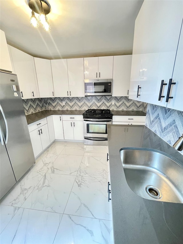 8385 116th St Unit 4B, Kew Gardens, NY 11418 - kitchen featuring appliances with stainless steel finishes, dark countertops, tasteful backsplash, and white cabinetry
