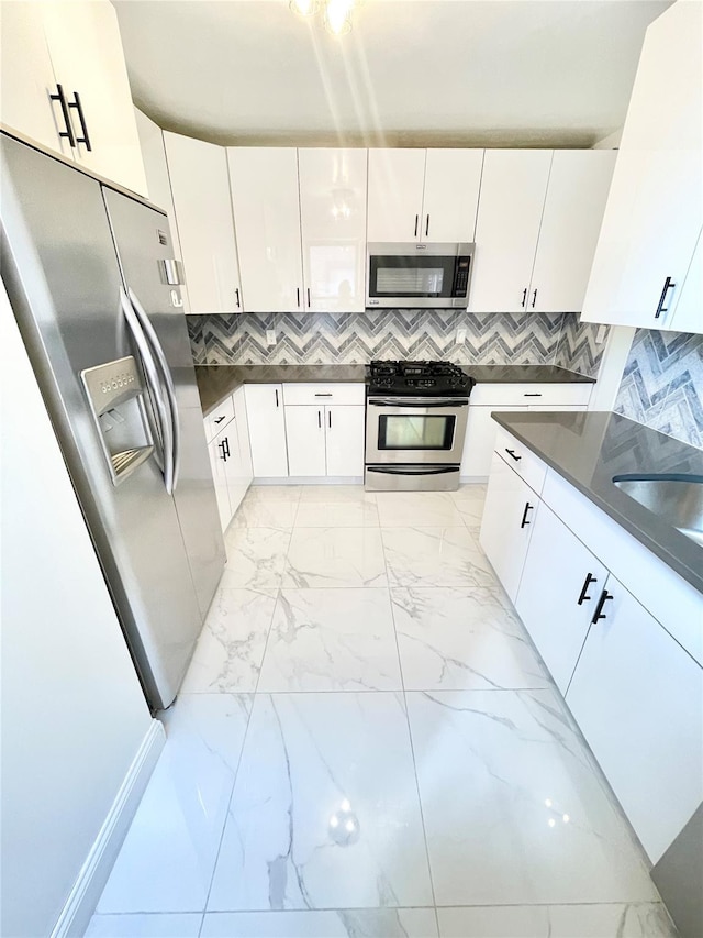 8385 116th St Unit 4B, Kew Gardens, NY 11418 - kitchen featuring stainless steel appliances, light marble finish floors, white cabinetry, and dark countertops