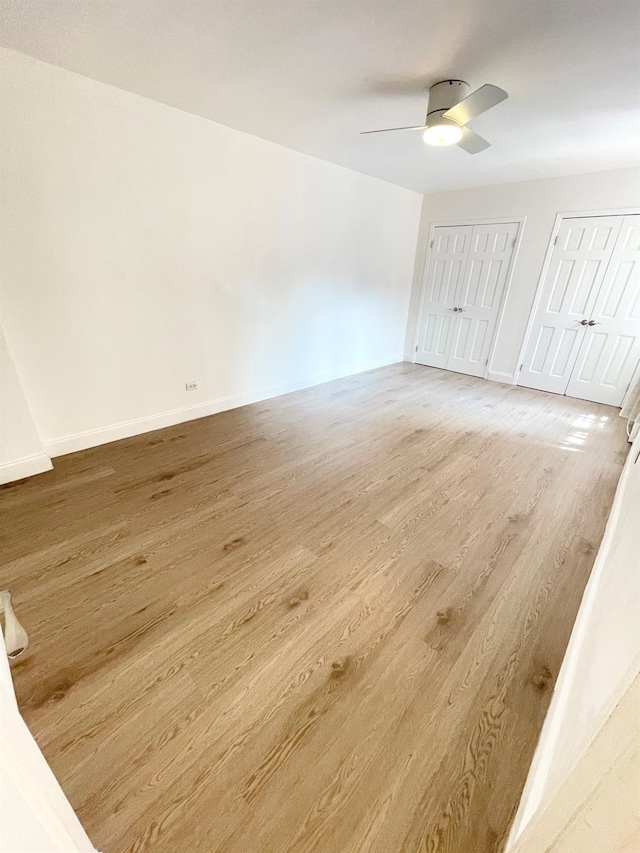 8385 116th St Unit 4B, Kew Gardens, NY 11418 - unfurnished bedroom featuring multiple closets, wood finished floors, and a ceiling fan