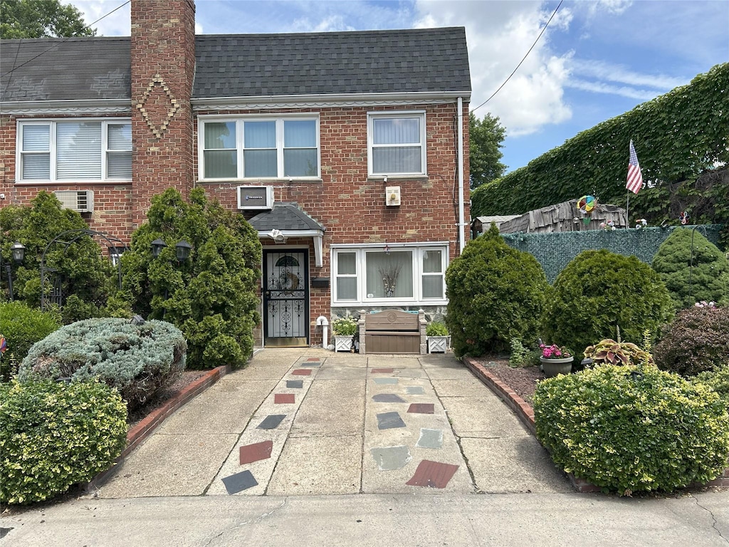60-23 60th Rd, Maspeth, NY 11378 - view of front facade featuring a shingled roof, brick siding, and a chimney