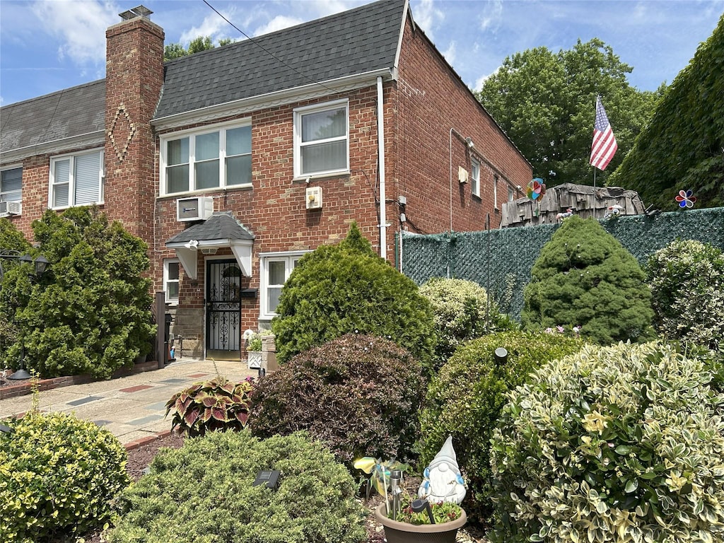 60-23 60th Rd, Maspeth, NY 11378 - view of front facade with brick siding, a shingled roof, and a chimney