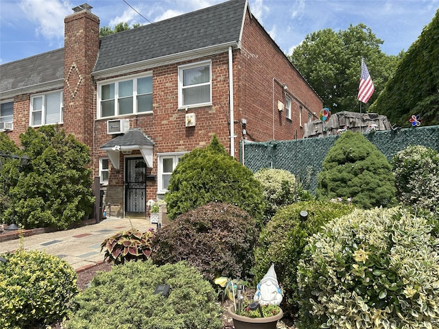 60-23 60th Rd, Maspeth, NY 11378 - view of front facade with brick siding, a shingled roof, and a chimney