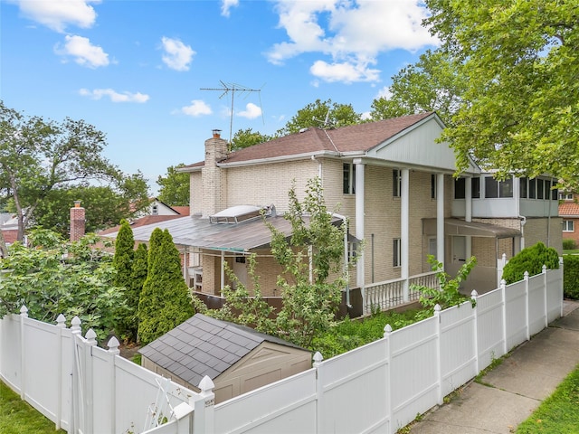 154-70 11th Ave, Beechhurst, NY 11357 - view of front of property featuring brick siding, a chimney, a fenced backyard, and roof with shingles