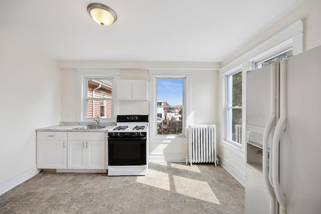 1639 Hone Ave, Bronx, NY 10461 - kitchen with white appliances, radiator heating unit, stone finish flooring, and white cabinetry