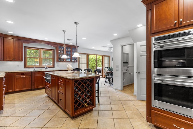 42 E Webster St, Merrick, NY 11566 - kitchen featuring stainless steel double oven, light tile patterned floors, light stone countertops, recessed lighting, and decorative light fixtures
