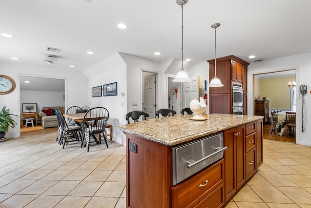 42 E Webster St, Merrick, NY 11566 - kitchen with a warming drawer, light tile patterned flooring, light stone countertops, recessed lighting, and a center island