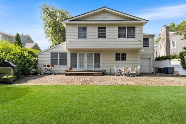42 E Webster St, Merrick, NY 11566 - rear view of property featuring a patio area, a lawn, entry steps, and a garage