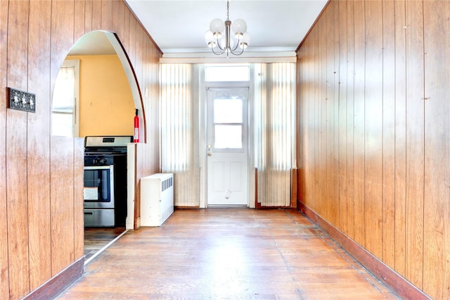 7914 Elks Rd, Elmhurst, NY 11373 - kitchen featuring gas range, wood finished floors, a chandelier, wooden walls, and arched walkways