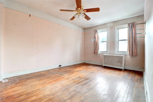 7914 Elks Rd, Elmhurst, NY 11373 - spare room featuring radiator heating unit, a ceiling fan, and wood-type flooring