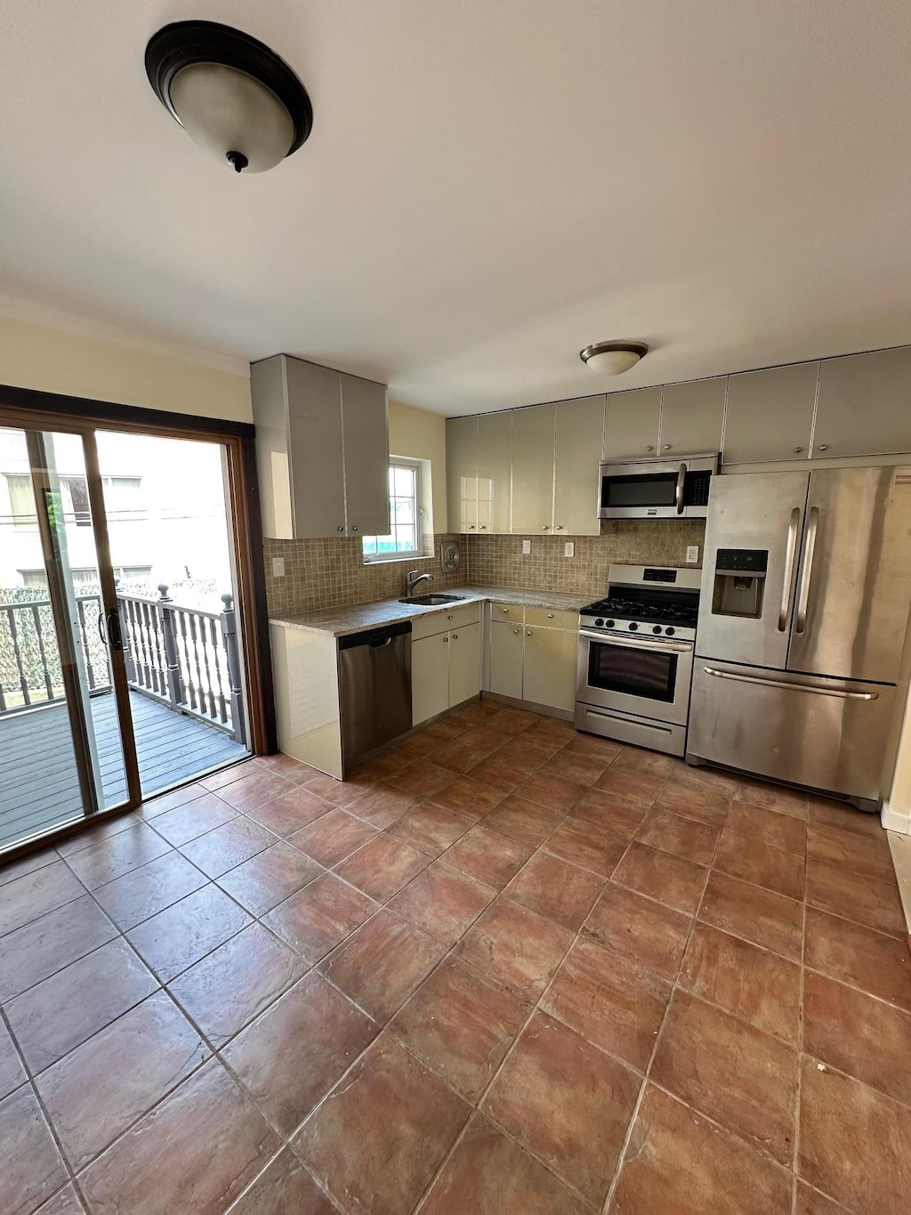 53-26 61st St, Maspeth, NY 11378 - kitchen featuring stainless steel appliances, tasteful backsplash, gray cabinetry, and light countertops