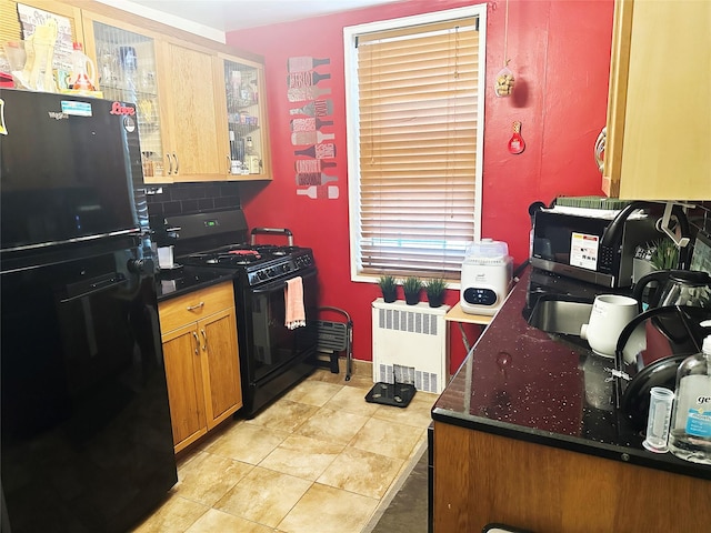 530 Dubois Ave Unit B3, Valley Stream, NY 11581 - kitchen featuring black appliances, radiator, brown cabinetry, light tile patterned flooring, and dark stone counters