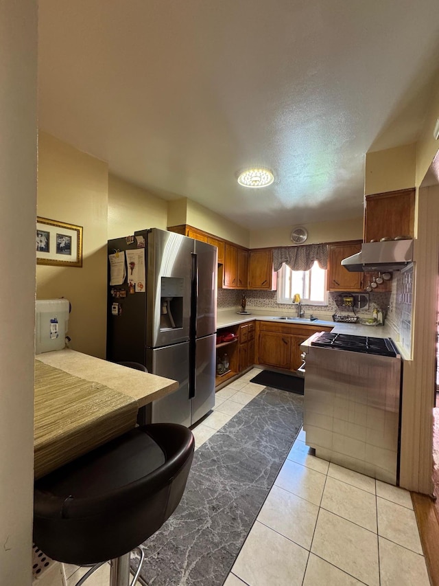 4406 Murdock Ave, Bronx, NY 10466 - kitchen with appliances with stainless steel finishes, range hood, tasteful backsplash, brown cabinetry, and light tile patterned floors