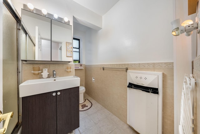 140-10 84th Dr Unit 2B, Briarwood, NY 11435 - bathroom featuring tile walls, tile patterned floors, vanity, and a wainscoted wall