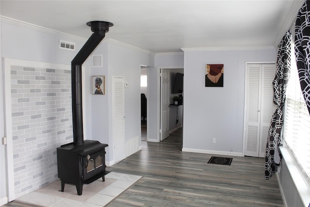 45 Tamarack St, Central Islip, NY 11722 - unfurnished living room featuring a wood stove, crown molding, and wood finished floors