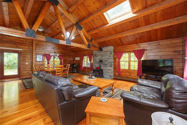 844 Salt Point Tpke, Pleasant Valley, NY 12601 - living room featuring a skylight, a wood stove, healthy amount of natural light, light wood-style floors, and wood walls