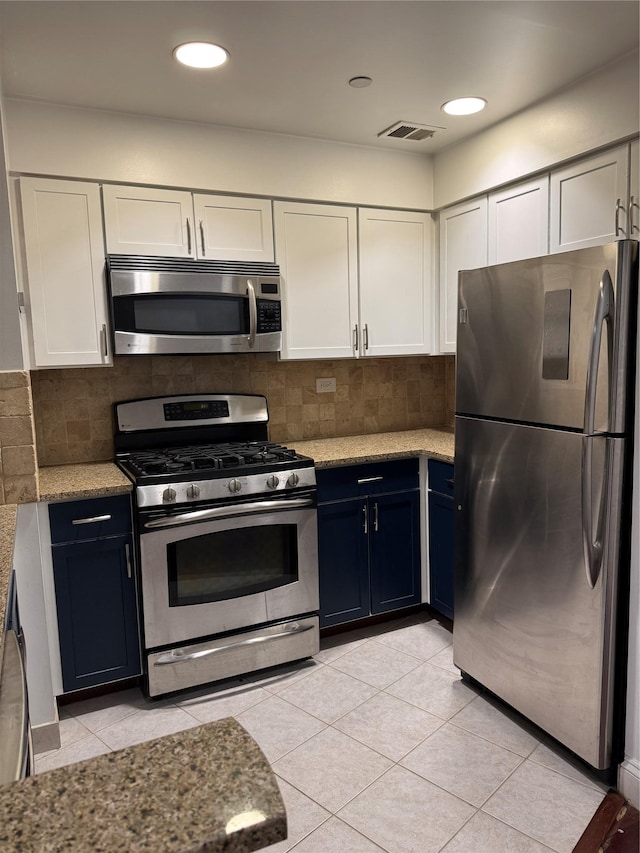 143-41 84th Dr Unit 1A, Briarwood, NY 11435 - kitchen with stainless steel appliances, white cabinetry, light stone counters, tasteful backsplash, and light tile patterned floors