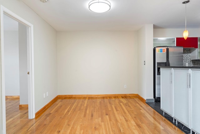 71-24 164th St Unit 2, Fresh Meadows, NY 11365 - kitchen with stainless steel fridge with ice dispenser, dark countertops, light wood-style flooring, and hanging light fixtures