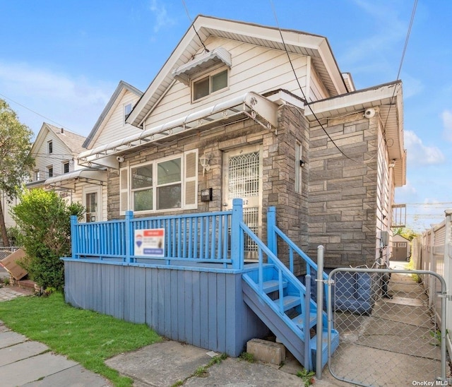 20-12 120th St, College Point, NY 11356 - view of front of property featuring stone siding and a gate