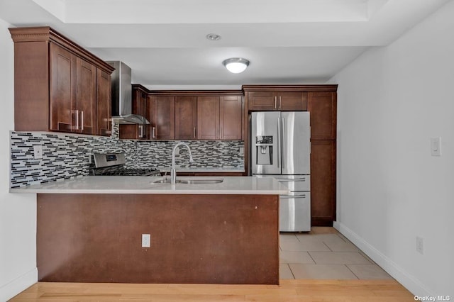 20-12 120th St, College Point, NY 11356 - kitchen featuring appliances with stainless steel finishes, wall chimney exhaust hood, a peninsula, tasteful backsplash, and light countertops