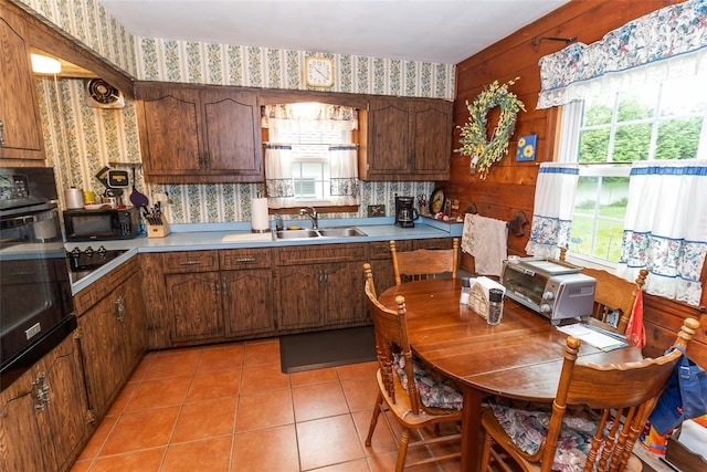 12 Greentree Ct, Northport, NY 11768 - kitchen with wallpapered walls, black appliances, light countertops, and light tile patterned flooring