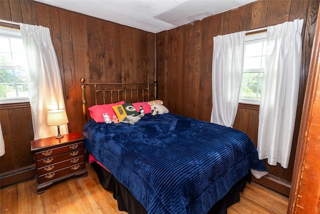 12 Greentree Ct, Northport, NY 11768 - bedroom with multiple windows, light wood-style flooring, wooden walls, and a baseboard heating unit