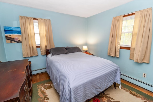 12 Greentree Ct, Northport, NY 11768 - bedroom with a baseboard radiator and wood finished floors