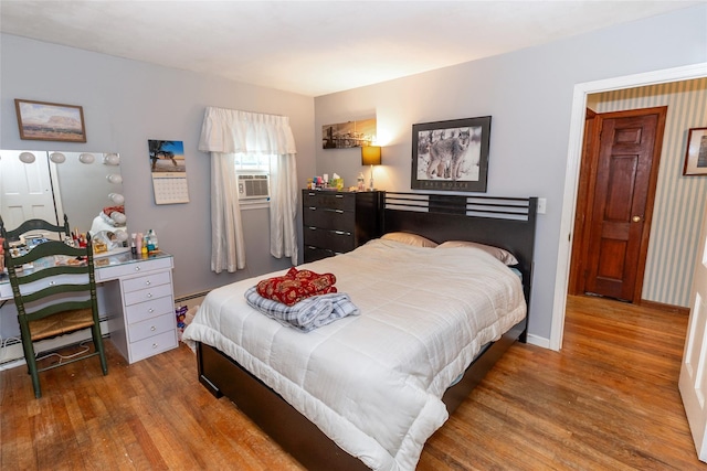 12 Greentree Ct, Northport, NY 11768 - bedroom featuring wood finished floors, cooling unit, and a baseboard radiator
