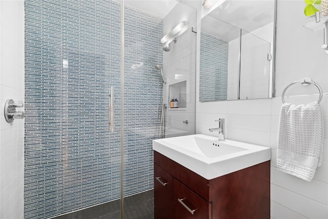 301 E 69th St Unit 4C, New York Manhattan, NY 10021 - bathroom with tile walls, tiled shower, vanity, and decorative backsplash