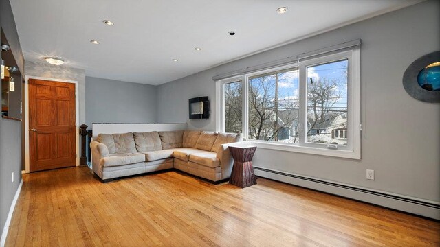 95 Foster Ave, Valley Stream, NY 11580 - living area with a baseboard heating unit, light wood-style floors, and recessed lighting
