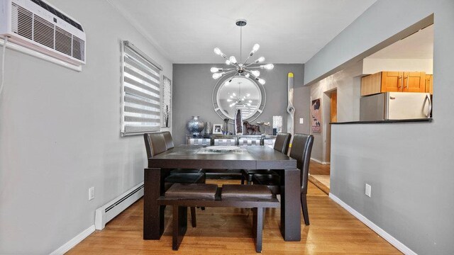 95 Foster Ave, Valley Stream, NY 11580 - dining area with a baseboard heating unit, a chandelier, light wood-style floors, and a wall unit AC