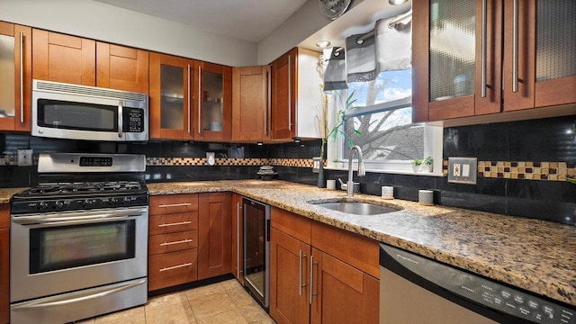 95 Foster Ave, Valley Stream, NY 11580 - kitchen featuring stainless steel appliances, wine cooler, brown cabinetry, and light stone countertops